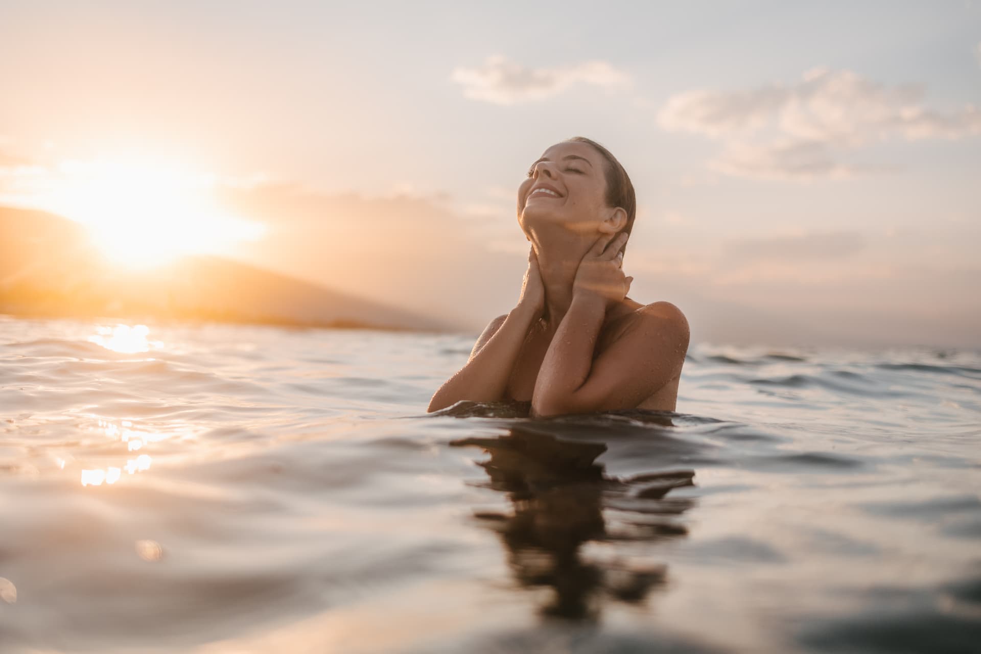 Woman relaxing in the ocean at sunset off West Maui, radiant healthy skin