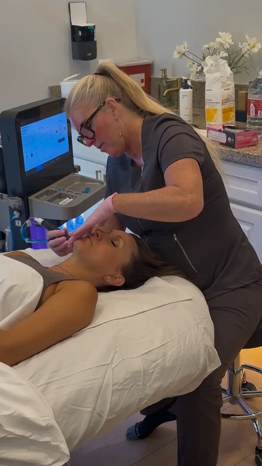 Stefanie Roberts guiding the HydraFacial wand across a guest's cheek in the Nō Ka ʻOi treatment room